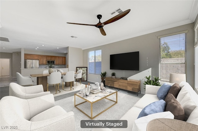 living room featuring crown molding and ceiling fan