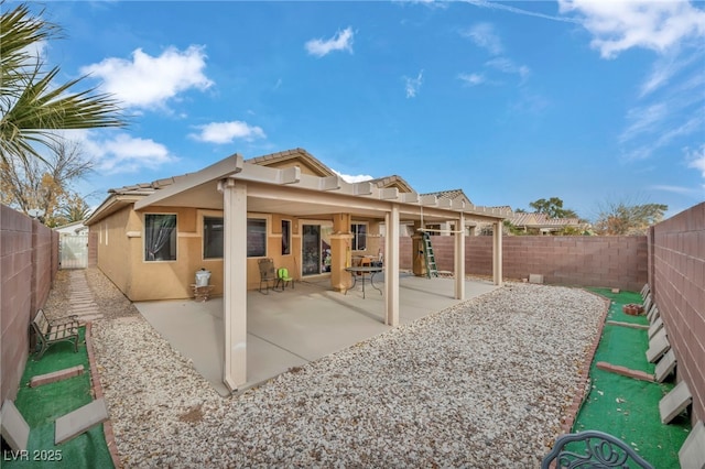 back of house with stucco siding, a fenced backyard, and a patio