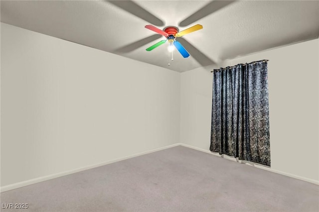 carpeted spare room with a textured ceiling, a ceiling fan, and baseboards