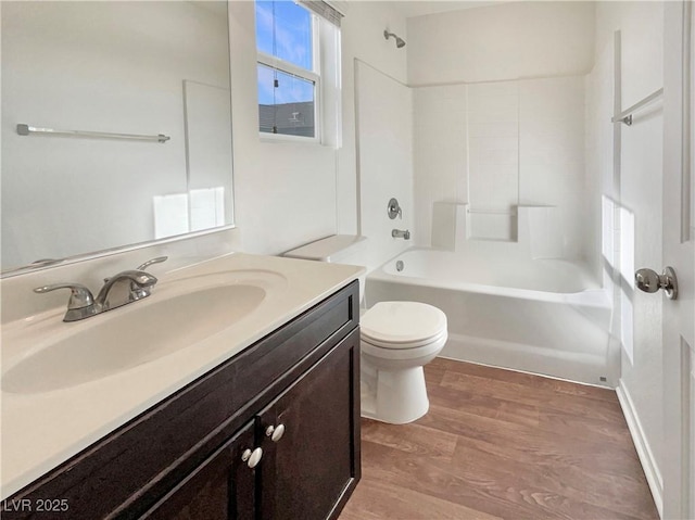 bathroom with tub / shower combination, vanity, toilet, and wood finished floors