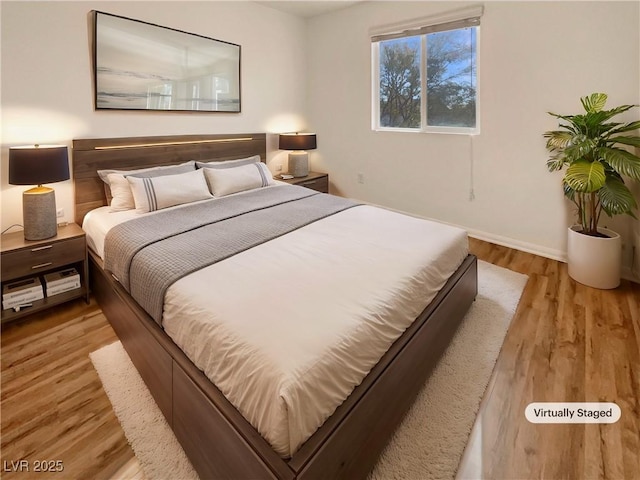 bedroom featuring baseboards and wood finished floors