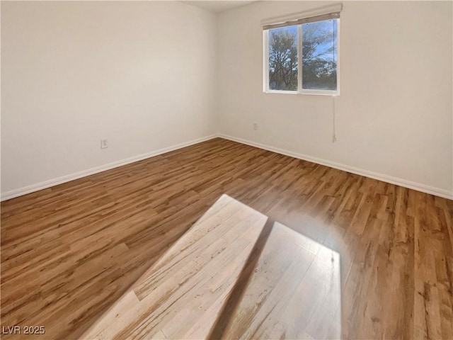 spare room with wood finished floors and baseboards