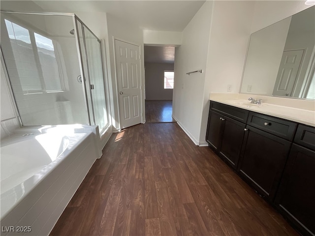 full bath with a stall shower, wood finished floors, and a bath