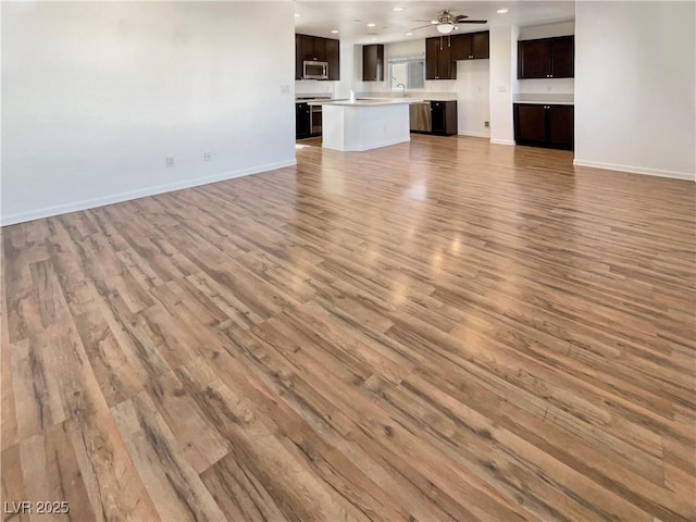 unfurnished living room with ceiling fan, light wood finished floors, recessed lighting, and baseboards