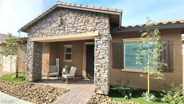 exterior space with a tiled roof, stone siding, and stucco siding