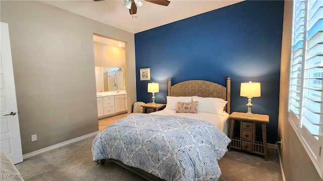 carpeted bedroom featuring baseboards, ceiling fan, and ensuite bath