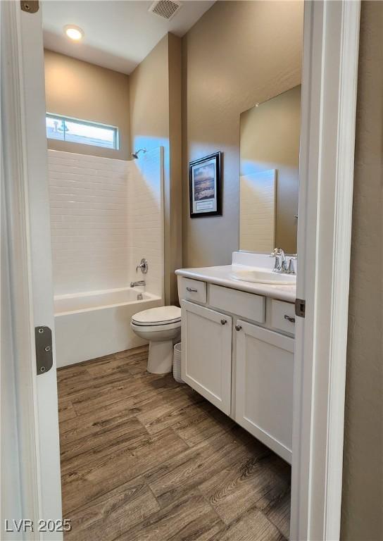 bathroom with shower / bath combination, vanity, toilet, and wood finished floors