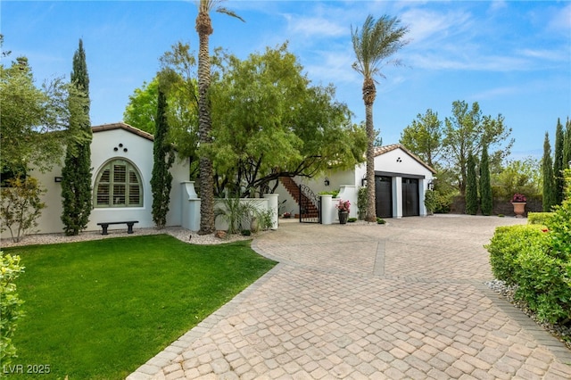 mediterranean / spanish-style house with a garage and a front lawn