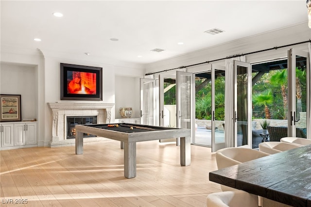 rec room featuring a premium fireplace, crown molding, pool table, and light hardwood / wood-style floors