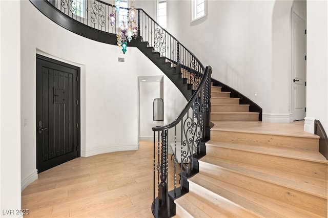 foyer entrance featuring light wood-type flooring and a high ceiling