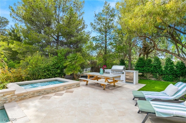 view of patio / terrace with area for grilling, an in ground hot tub, and exterior kitchen