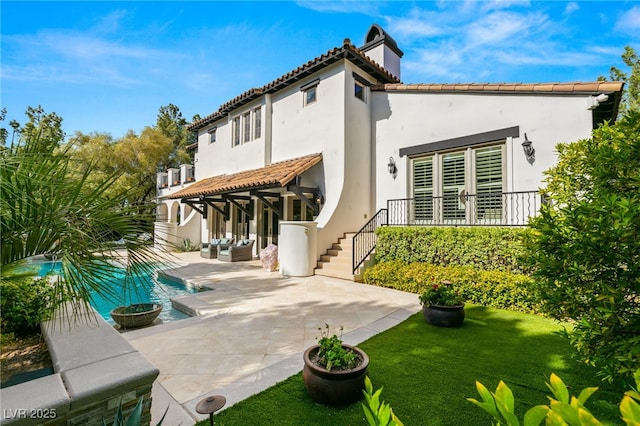 back of property featuring a patio and a lawn