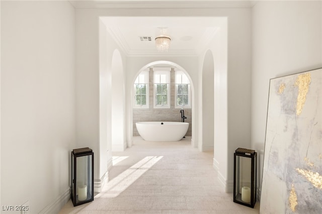 bathroom featuring crown molding and a washtub