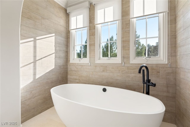 bathroom with a bathing tub and tile walls