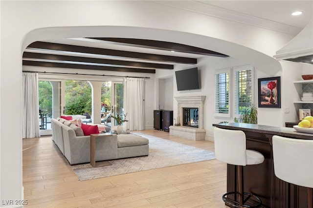 living room featuring beam ceiling and light wood-type flooring