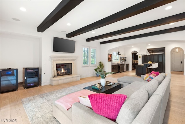 living room featuring beamed ceiling and wood-type flooring