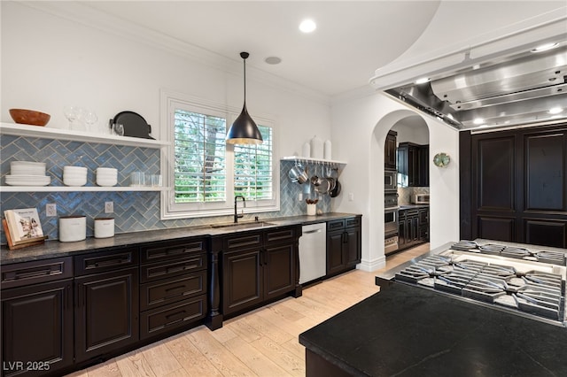 kitchen with appliances with stainless steel finishes, pendant lighting, tasteful backsplash, sink, and custom exhaust hood