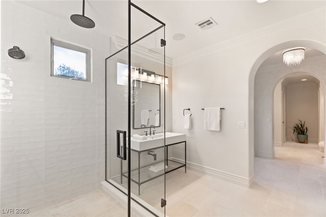 bathroom featuring a tile shower and crown molding