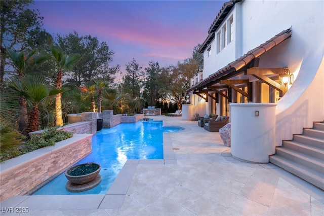 pool at dusk with a patio