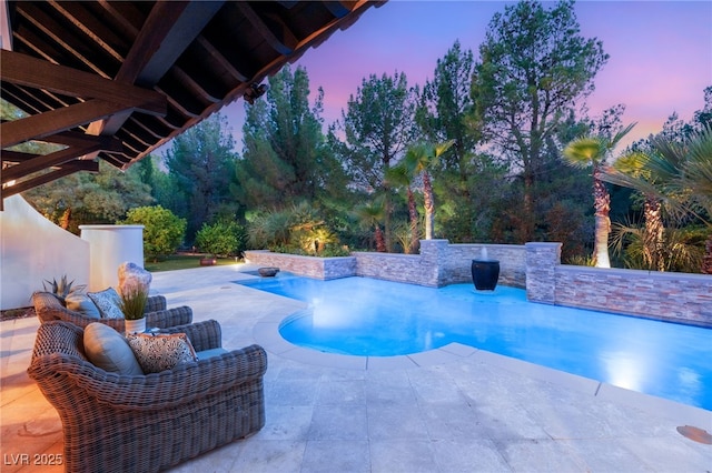 pool at dusk with a patio area