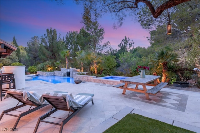 patio terrace at dusk with a pool with hot tub