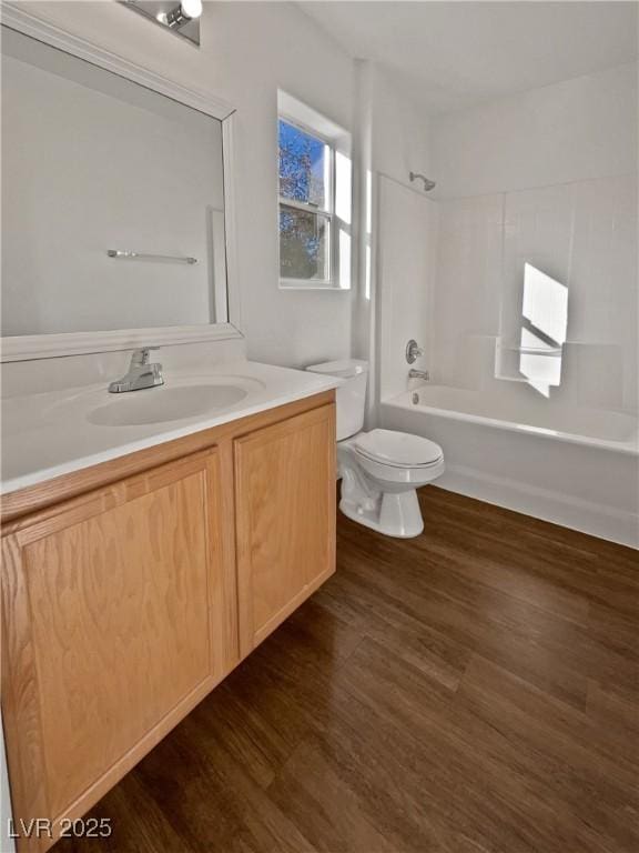 full bathroom with shower / washtub combination, toilet, hardwood / wood-style floors, and vanity