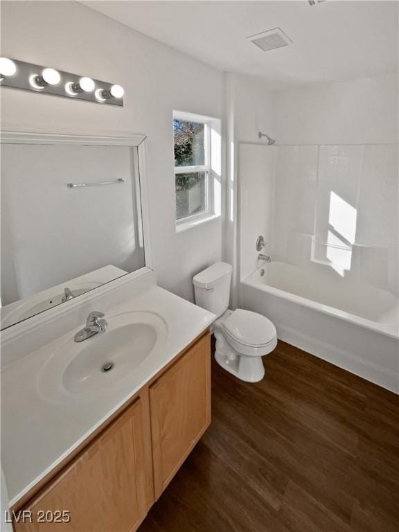 full bathroom with shower / bath combination, wood-type flooring, vanity, and toilet