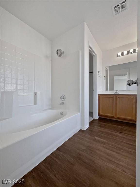 bathroom with hardwood / wood-style flooring, vanity, and tub / shower combination