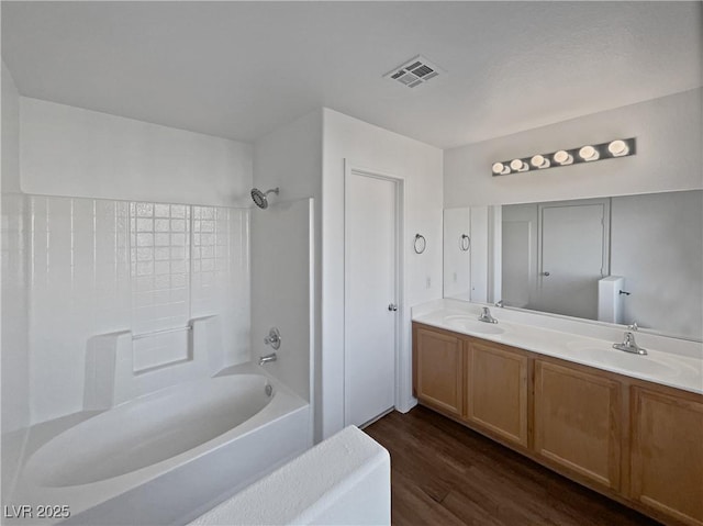 bathroom with wood-type flooring, shower / bathing tub combination, and vanity