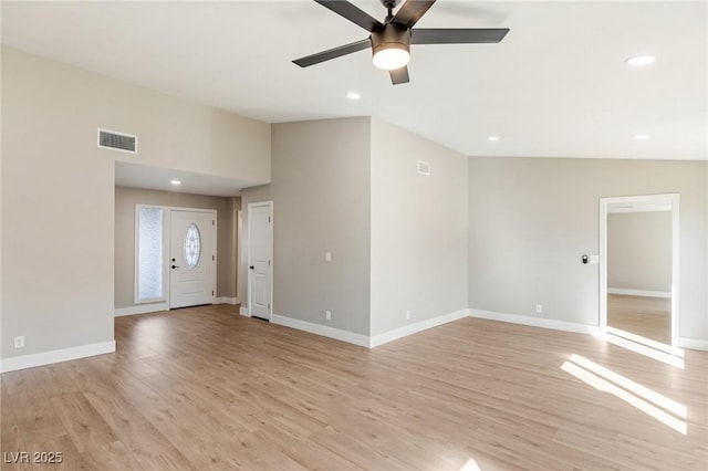 unfurnished living room featuring ceiling fan, lofted ceiling, and light wood-type flooring