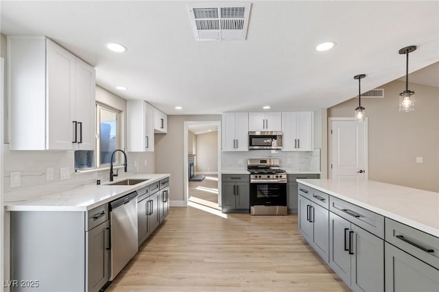 kitchen featuring gray cabinets, appliances with stainless steel finishes, sink, and white cabinets