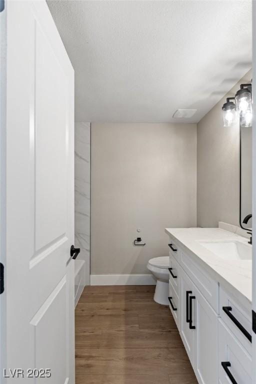 bathroom featuring hardwood / wood-style flooring, vanity, and toilet