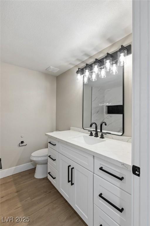 bathroom with vanity, hardwood / wood-style floors, and toilet