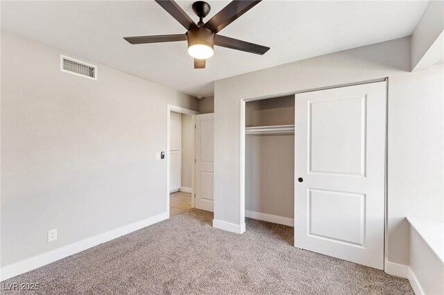 unfurnished bedroom featuring light colored carpet, a closet, and ceiling fan