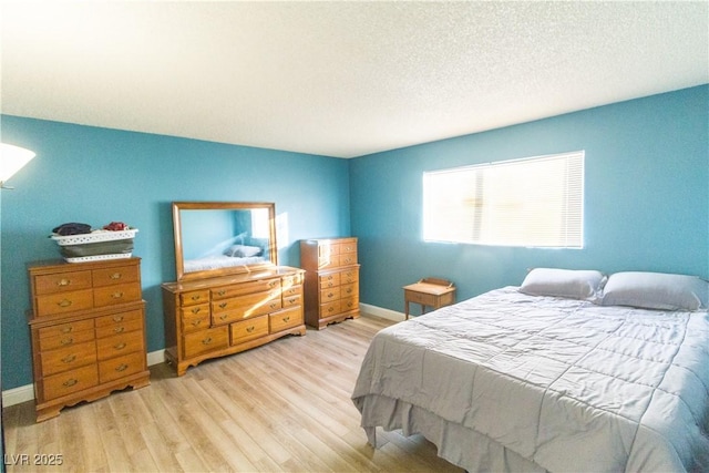 bedroom featuring light hardwood / wood-style floors and a textured ceiling