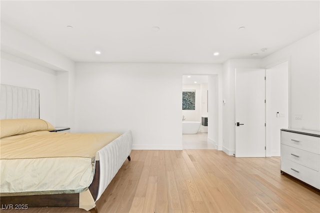 bedroom featuring light hardwood / wood-style flooring and ensuite bathroom