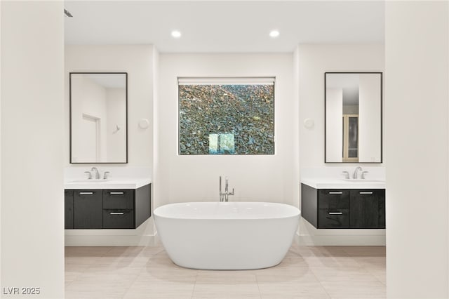 bathroom featuring tile patterned flooring, vanity, and a bathtub