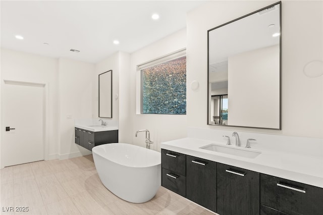 bathroom with vanity and a washtub