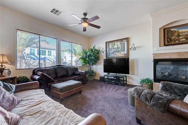 carpeted living room with a fireplace and ceiling fan