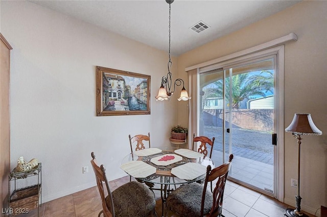 dining space featuring light tile patterned flooring and a notable chandelier