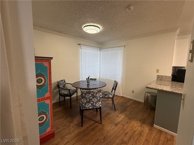 dining area featuring crown molding, dark hardwood / wood-style flooring, and a textured ceiling