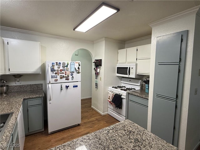 kitchen with dark hardwood / wood-style floors, white cabinetry, crown molding, and white appliances