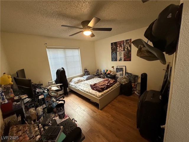 bedroom featuring hardwood / wood-style floors, a textured ceiling, and ceiling fan