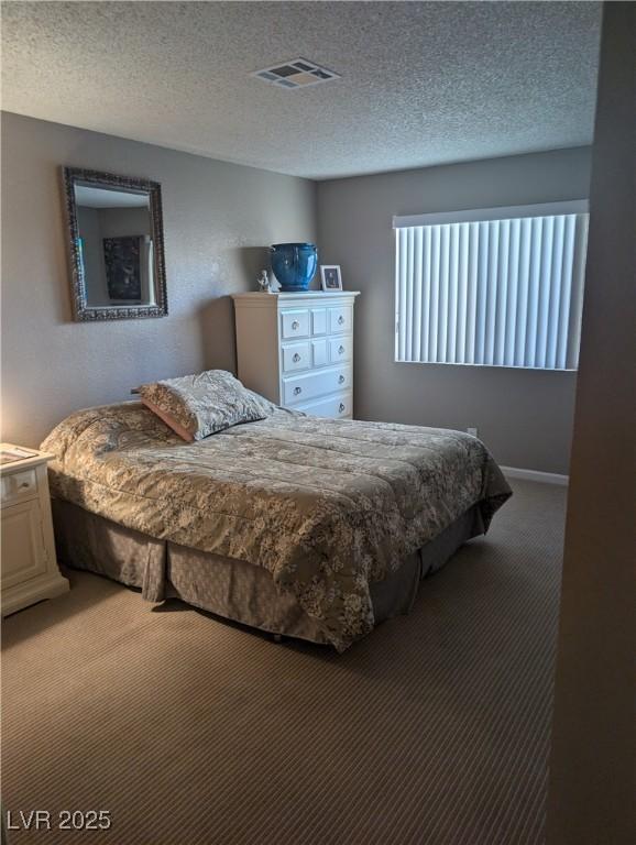 carpeted bedroom with a textured ceiling