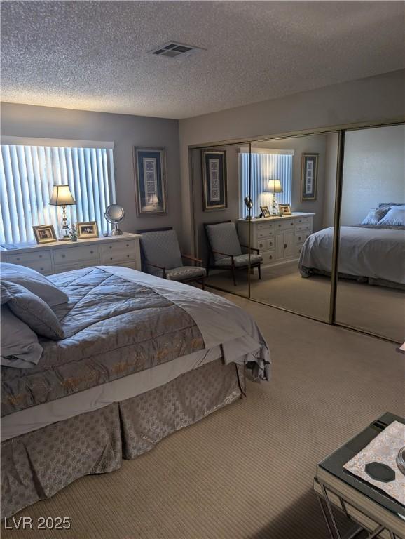 bedroom with a closet, a textured ceiling, and carpet flooring