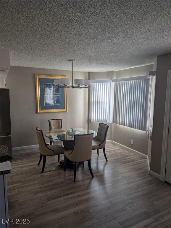 dining space featuring dark hardwood / wood-style flooring and a textured ceiling