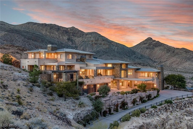 back house at dusk with a balcony and a mountain view