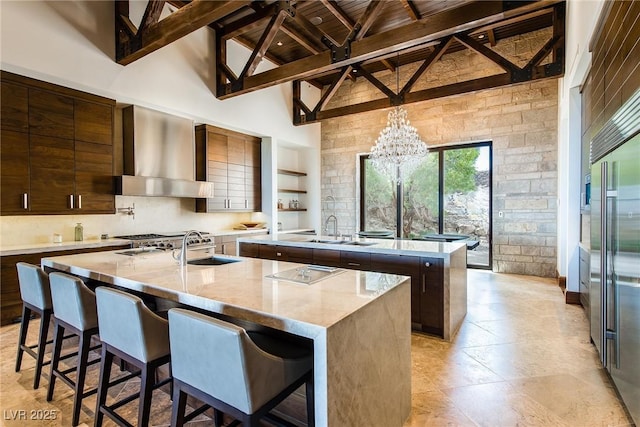 kitchen with wall chimney exhaust hood, wood ceiling, high vaulted ceiling, an island with sink, and beamed ceiling