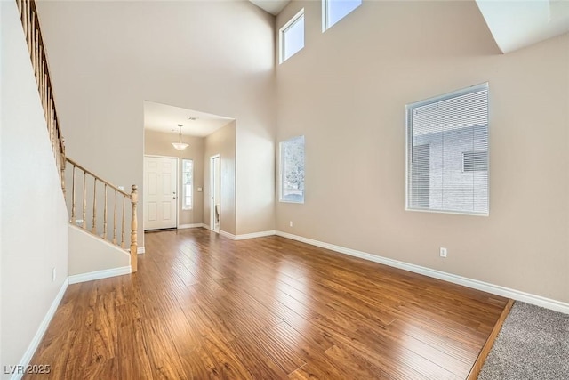 entryway featuring a high ceiling, wood-type flooring, and a healthy amount of sunlight