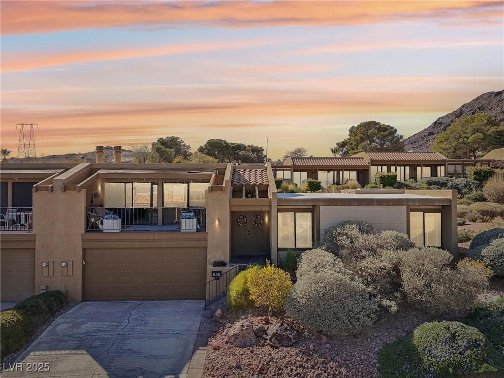 view of front of property featuring a balcony and a mountain view